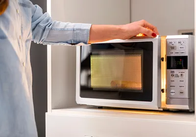 Image of a person closing a microwave oven door